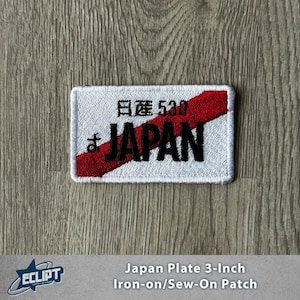 May include: Rectangular white patch with a red diagonal stripe and black text that reads "JAPAN". The patch also features Japanese characters and the number "530". The patch is approximately 7.6 cm wide.