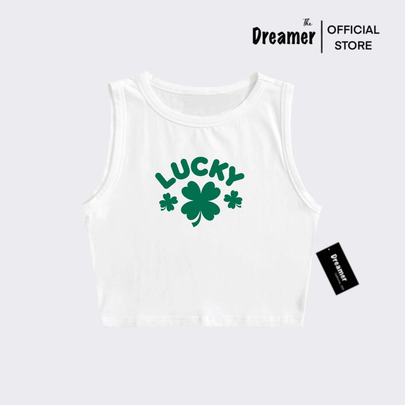 May include: White sleeveless crop top with a green shamrock and the word "LUCKY" printed on the front.