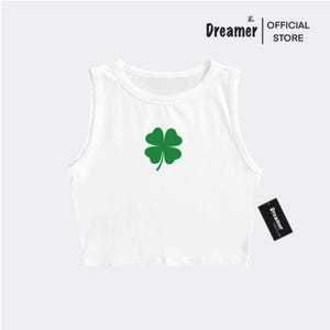 May include: White sleeveless crop top with a green four-leaf clover graphic.