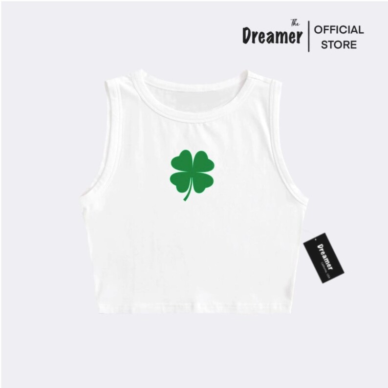 May include: White sleeveless crop top with a green four-leaf clover graphic.
