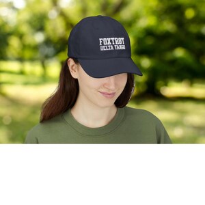 Może przedstawiać: Czapka bejsbolowa w kolorze granatowym z białym haftem z napisem "FOXTROT DELTA TANGO".