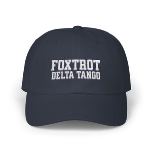 Może przedstawiać: Czapka bejsbolowa w kolorze granatowym z białym haftem z napisem "FOXTROT DELTA TANGO".