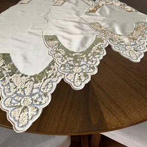 May include: Three ivory table runners with a scalloped edge and a decorative design of gold and silver sequins.