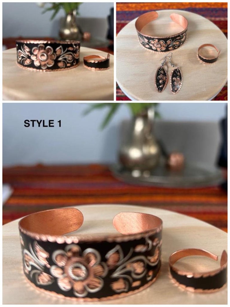 May include: A set of copper jewelry with black enamel and floral designs. The set includes a bracelet, a ring, and a pair of earrings. STYLE 1 is written on the image.