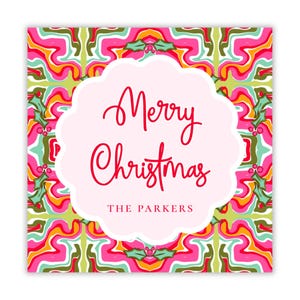 May include: Square Christmas card with a pink scalloped border. The card features the words "Merry Christmas" in red script, with "THE PARKERS" below. The background has a colorful, abstract pattern with pink, green, and orange.