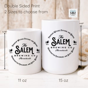 Puede incluir: Taza de cer&aacute;mica blanca con un gr&aacute;fico en blanco y negro de un caldero de bruja y el texto "The Salem Brewing Co. Est. 1626 Massachusetts Handcrafted Cauldrons and Spell Books" en un c&iacute;rculo. La taza est&aacute; disponible en dos tama&ntilde;os: 11 oz y 15 oz.