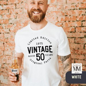 Peut inclure: T-shirt blanc avec un graphique circulaire noir qui dit "&Eacute;dition limit&eacute;e 1975 Vintage &Acirc;g&eacute; de 50 ans Pi&egrave;ces d'origine".