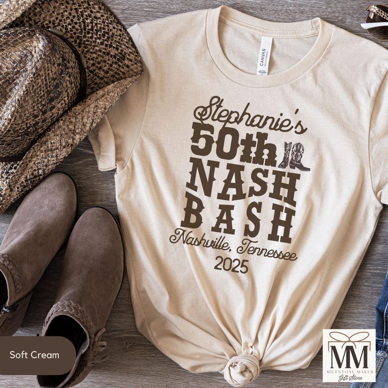 May include: A beige t-shirt with a brown graphic design that says "Stephanie's 50th Nash Bash Nashville, Tennessee 2025".