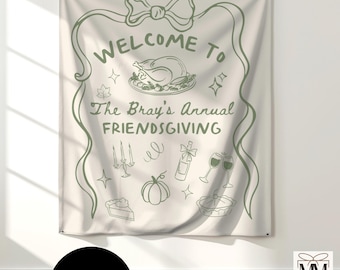 May include: Off-white fabric banner with green line art. The banner reads "Welcome to The Bray's Annual Friendsgiving" with illustrations of a turkey, pie, and other festive elements. A black circle at the bottom says "CUSTOM".