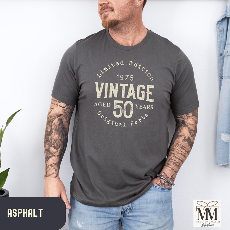 Peut inclure: Un t-shirt gris fonc&eacute; avec le texte "Limited Edition 1975 Vintage Aged 50 Years Original Parts" imprim&eacute; sur le devant.