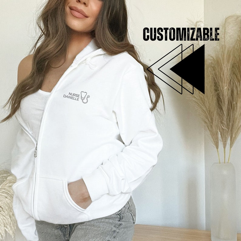 May include: White zippered hoodie with a stethoscope and the text "Nurse Danielle" on the front. The hoodie is customizable.