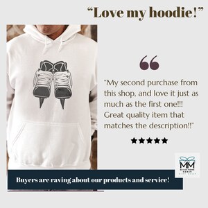 Op de afbeelding: Witte hoodie met een zwart-witte afbeelding van schaatsen. De tekst "Love my hoodie!" staat boven de afbeelding. De tekst "My second purchase from this shop, and love it just as much as the first one!!! Great quality item that matches the description!!" staat onder de afbeelding. Vijf sterren staan onder de tekst. De tekst "Buyers are raving about our products and service!" staat onder de sterren. De tekst "MM MILESTONE MAKER GIFT SHOP" staat in de rechterbenedenhoek van de afbeelding.