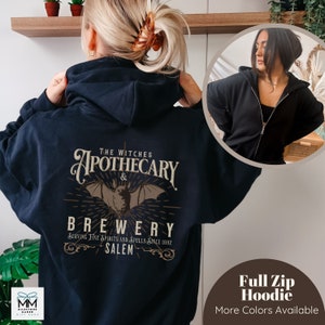 May include: A black full zip hoodie with a vintage-style graphic on the back that reads "The Witches Apothecary & Brewery Serving Fine Spirits and Spells Since 1692 Salem".