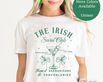May include: White t-shirt with a green graphic design that says "The Irish Social Club" with a martini glass, shamrocks, and the text "Dublin, Ireland" and "Est. 1892". The graphic also says "Home of Shenanigans & Tomfooleries".