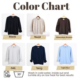 K&ouml;nnte beinhalten: Farbkarte mit verschiedenen Farben von Sweatshirts. Die Farben sind Schwarz, Sand, Schokoladenbraun, Asche, Marineblau und Hellblau. Die Karte enth&auml;lt Waschanweisungen: in kaltem Wasser waschen, auf links drehen und bei niedriger Hitze trocknen f&uuml;r beste Ergebnisse.