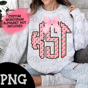 May include: A gray sweatshirt with a pink and green monogram design. The monogram is surrounded by a gold glitter outline. The monogram is in the shape of the letters "KSJ". A pink and white gingham bow is above the monogram. The text "CUSTOM MONOGRAM ALPHABET NOT INCLUDED" is in white text on a black background.
