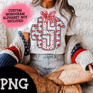 Puede incluir: Camiseta blanca con un diseño de monograma con estrellas, rayas y patrones florales rojos, blancos y azules. El diseño incluye un lazo a rayas rojas y blancas en la parte superior. El texto de la imagen dice "CUSTOM MONOGRAM ALPHABET NOT INCLUDED" y "PNG".