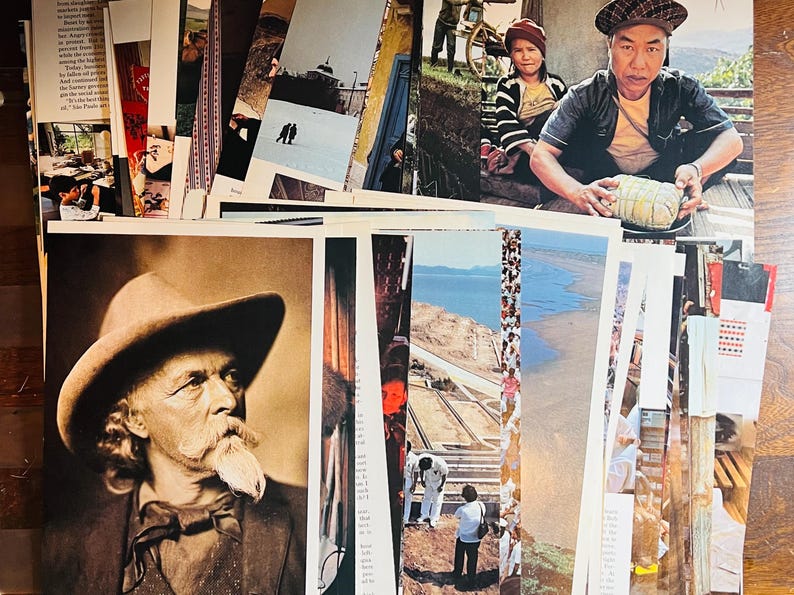 May include: A collection of vintage postcards featuring a variety of subjects, including a man in a hat, a landscape with a river, and a group of people. The postcards are in various colors and sizes, and some have handwritten notes on the back.