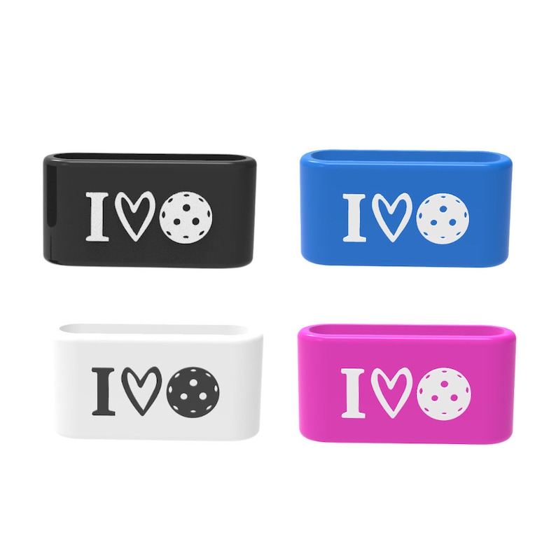 Op de afbeelding: Vier rechthoekige siliconen bandjes in zwart, blauw, wit en roze. Elk bandje heeft de tekst "I &hearts;" gevolgd door een pickleball-afbeelding. De bandjes zijn ontworpen met een afgeronde rechthoekige vorm.