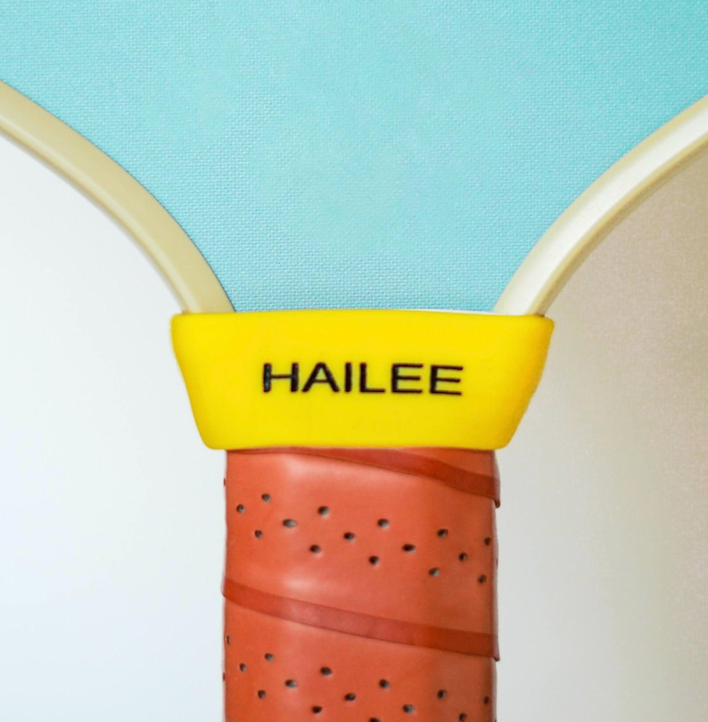 Puede incluir: Primer plano de una pala amarilla y roja con la palabra "HAILEE" impresa en la empu&ntilde;adura amarilla.