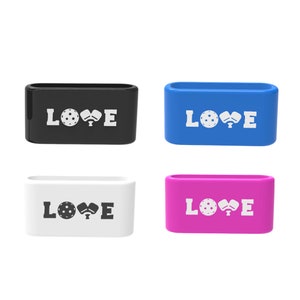 Op de afbeelding: Vier rechthoekige containers in zwart, blauw, wit en roze. Elke container heeft het woord "LOVE" in het wit, met een pickleball- en paddle-afbeelding. De containers zijn waarschijnlijk voor pickleball-liefhebbers.