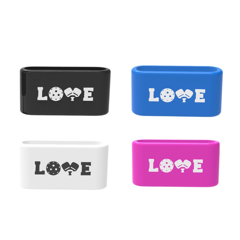 Op de afbeelding: Vier rechthoekige containers in zwart, blauw, wit en roze. Elke container heeft het woord "LOVE" in het wit, met een pickleball- en paddle-afbeelding. De containers zijn waarschijnlijk voor pickleball-liefhebbers.