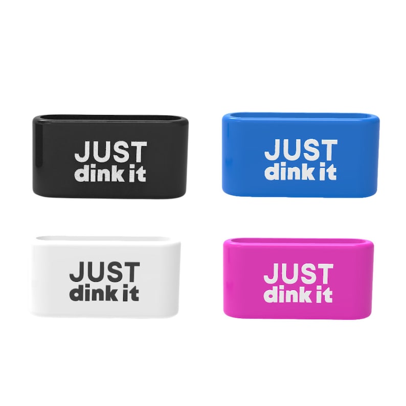 Op de afbeelding: Vier rechthoekige drankhouders in zwart, blauw, wit en roze. Elke houder heeft afgeronde hoeken en de woorden "JUST dink it" in witte blokletters.
