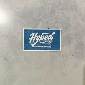 May include: A blue square sticker with white text that reads "Hyped Graphics" and "Custom Vinyl Stickers".