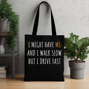 May include: Black tote bag with white text that reads "I might have MS and I walk slow but I drive fast". The "MS" is in orange.