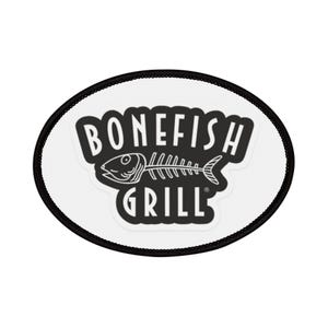 Peut inclure: Écusson ovale avec une bordure noire et un fond blanc. L'écusson présente les mots "BONEFISH GRILL" en gras, en noir, avec un dessin d'arête de poisson au centre.