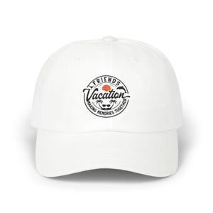 May include: White baseball cap with a curved brim. The cap features a circular graphic with the words "Friends Vacation Making Memories Together" around a design of a sun, palm trees, and sunglasses. The cap is a classic, casual accessory.