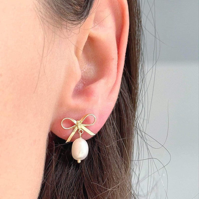 Single earring on ear with warm natural light. Shows scale and feminine detail—perfect for minimalist jewelry lovers and romantic gift for her ideas.