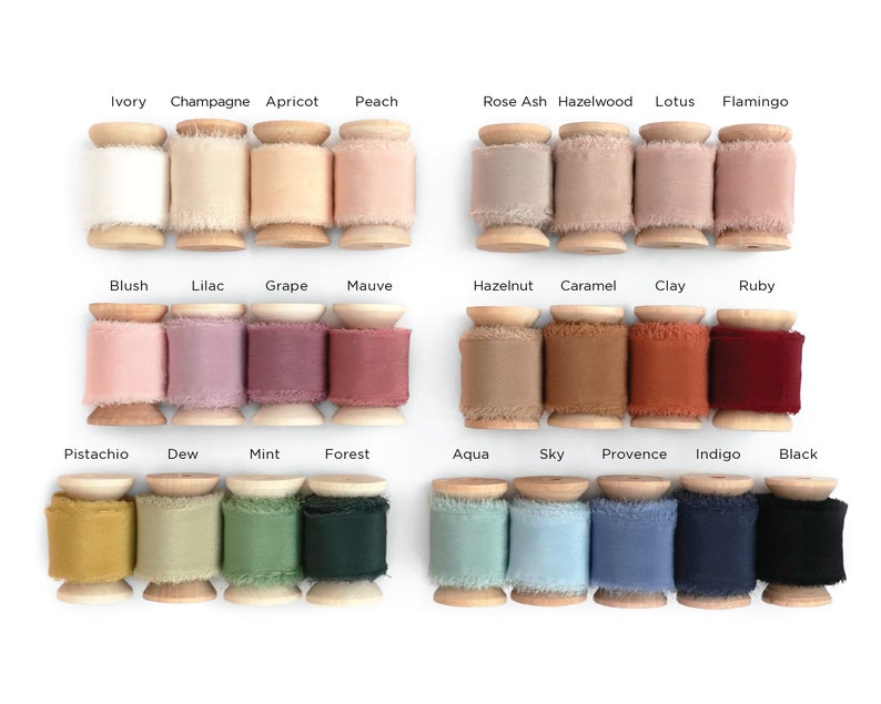 May include: A collection of 20 spools of ribbon in various colors, including ivory, champagne, apricot, peach, rose ash, hazelwood, lotus, flamingo, blush, lilac, grape, mauve, hazelnut, caramel, clay, ruby, pistachio, dew, mint, forest, aqua, sky, provence, indigo, and black. The spools are made of wood and have a frayed edge.