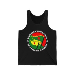 May include: Black tank top with a white circle graphic featuring a green, red, and yellow flag with two red stars. The circle graphic also includes the text "Solidarity with Rojava", "Stop Fascism", and "Rise Up".