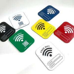 May include: A set of ten square signs with the words "FREE WIFI" printed on them. Each sign has a different colour background: black, white, blue, yellow, red, and green. The signs also include a wifi symbol, the words "NETWORK" and "PASSWORD", and a QR code.