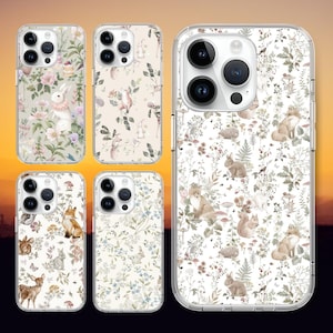 Könnte beinhalten: Satz mit fünf transparenten Handyhüllen mit weißem Hintergrund und einem Blumenmuster mit Füchsen, Kaninchen und anderen Waldtieren. Die Hüllen sind für iPhones konzipiert.