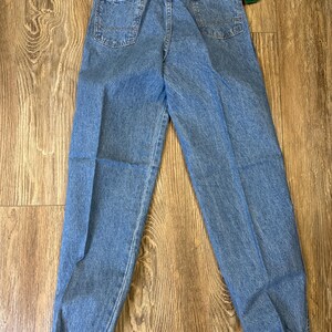 K&ouml;nnte beinhalten: Hellblaue Jeanshose mit elastischem Bund und elastischen B&uuml;ndchen. Die Hose hat zwei Ges&auml;&szlig;taschen und ein Etikett mit der Aufschrift "Wrangler". Hergestellt aus strapazierf&auml;higem Denim.
