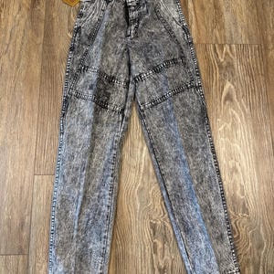 K&ouml;nnte beinhalten: S&auml;uregewaschene Jeans aus Denim mit Knopf- und Rei&szlig;verschluss. Die Jeans haben ein verblasstes Schwarz-Grau-Muster, verst&auml;rkte N&auml;hte und ein Etikett. Die Jeans haben ein klassisches F&uuml;nf-Taschen-Design.