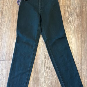 May include: Dark green high-waisted jeans with a button and zipper closure. The jeans have a straight leg fit and are made of a soft, comfortable fabric.