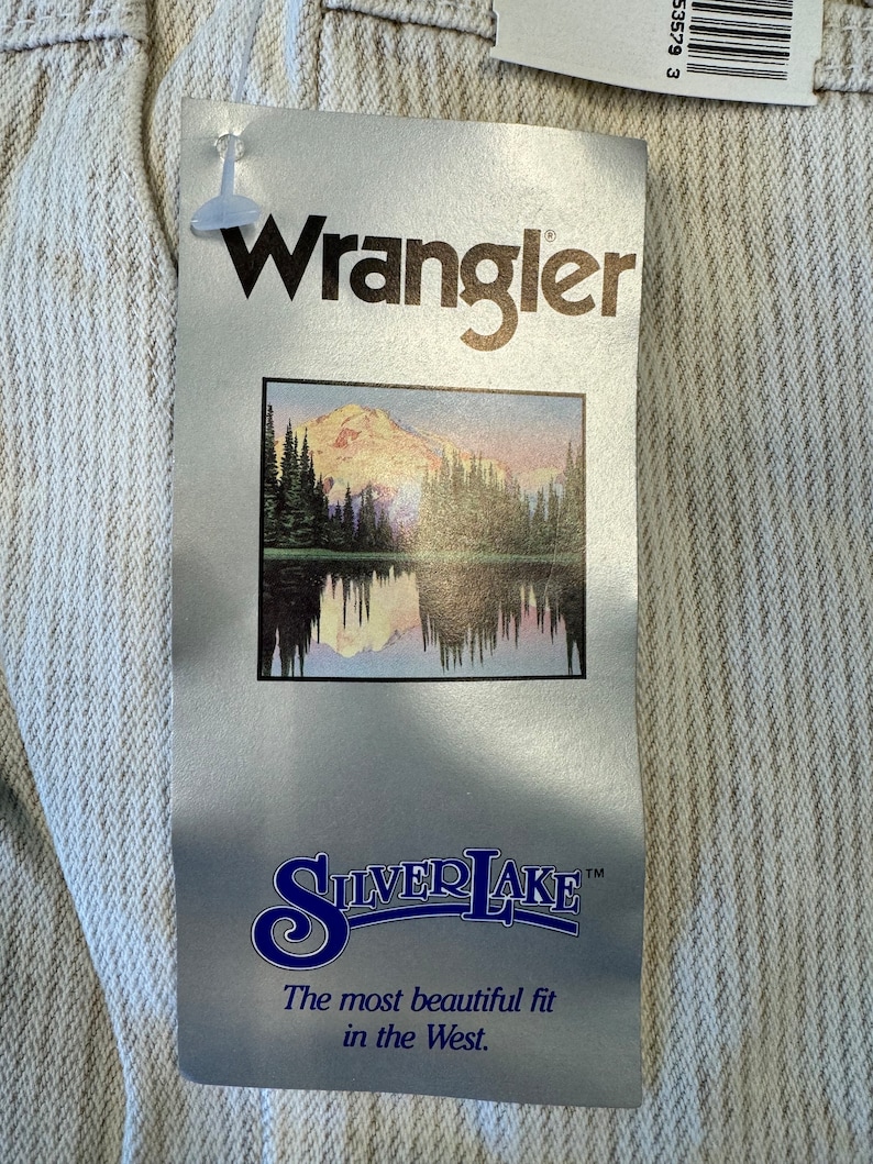 May include: A white Wrangler Silverlake jeans tag with a mountain scene and the text "The most beautiful fit in the West."