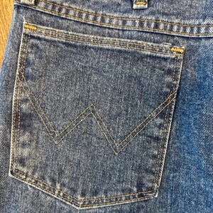 May include: A pair of blue denim jeans with a back pocket featuring a distinctive stitched 'W' design.