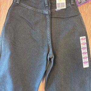 May include: A pair of dark wash Wrangler jeans with a classic fit. The jeans have a size tag that reads "Classic Fit 3/4 x 34 Cowboy Cut".