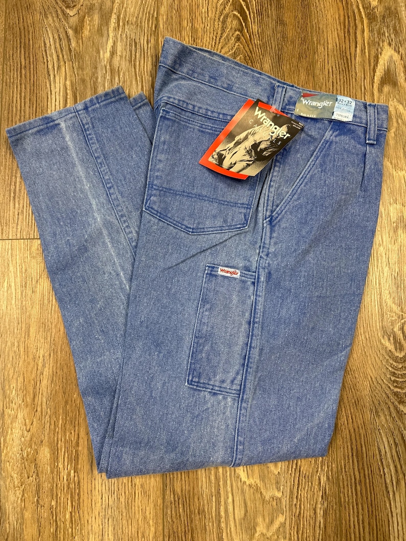 May include: Light blue Wrangler jeans with a straight leg and multiple pockets. The jeans have a faded wash and a red and white Wrangler tag. The waist size is 32 inches, and the inseam is 32 inches.