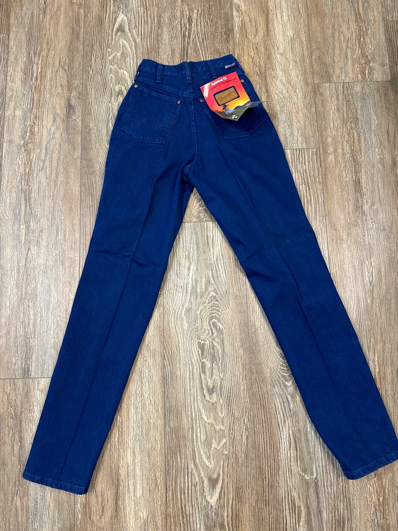 May include: A pair of dark blue denim jeans with a