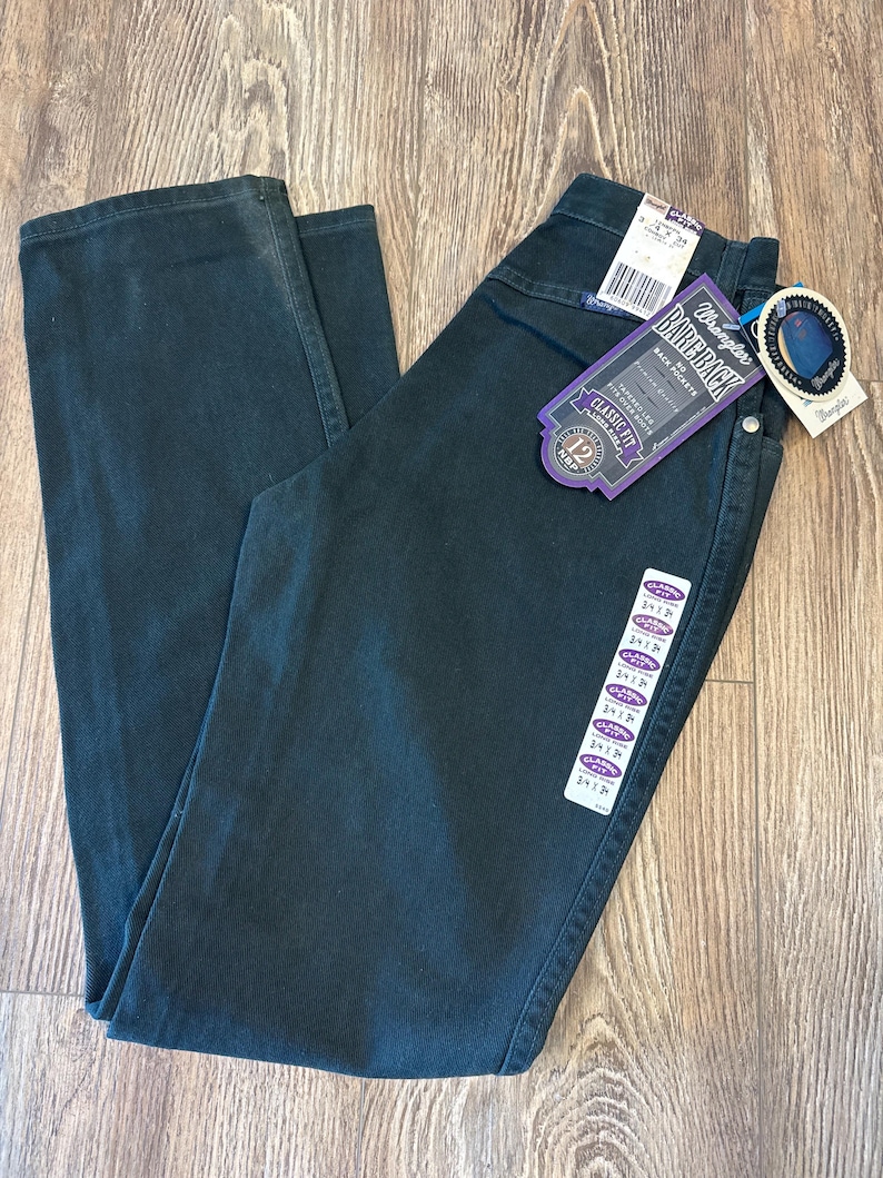May include: A pair of dark green Wrangler jeans with a purple tag that says "Bareback" and "Classic Fit".