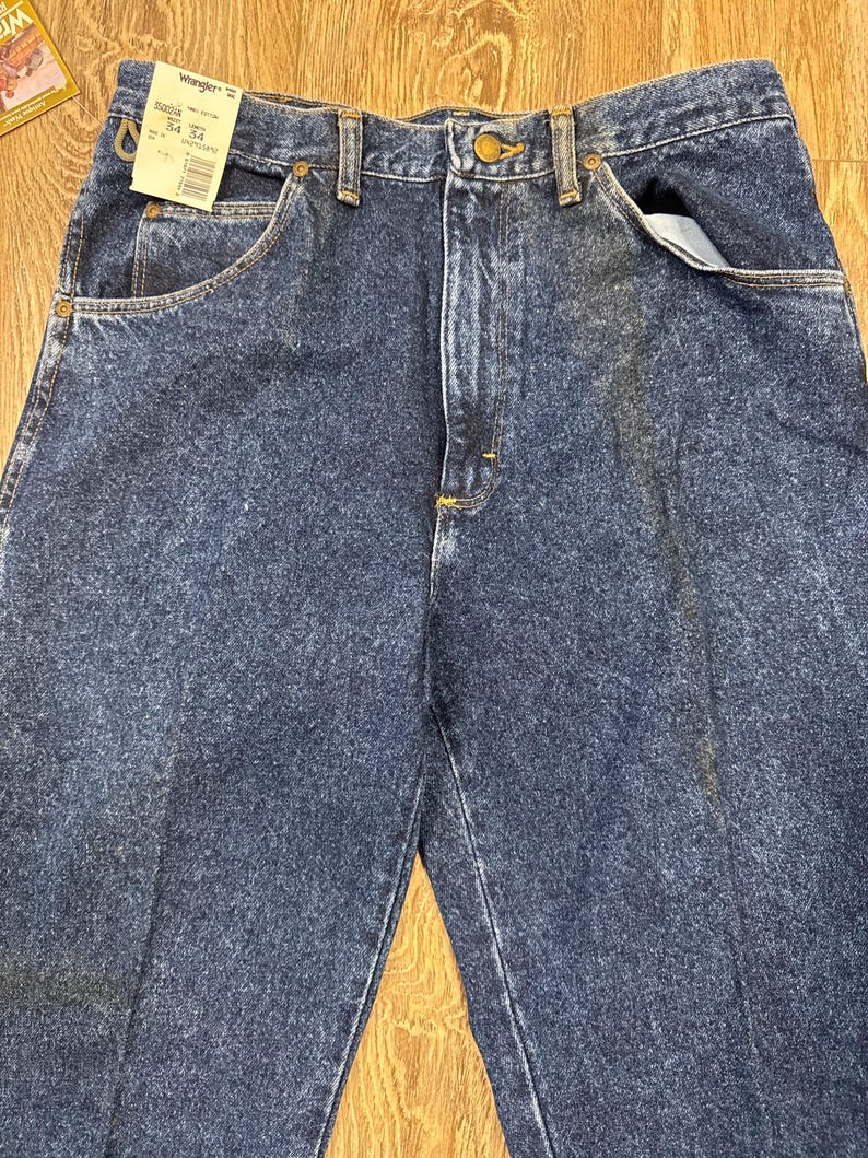 Puede incluir: Vaqueros de mezclilla azul oscuro con un dise&ntilde;o cl&aacute;sico de cinco bolsillos. Los vaqueros tienen cierre de bot&oacute;n y cremallera, y la etiqueta indica una cintura de 86 cm y una entrepierna de 86 cm. Los vaqueros est&aacute;n hechos de un material de mezclilla duradero.