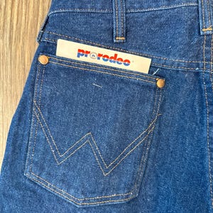 May include: A pair of blue denim jeans with a back pocket featuring a stitched