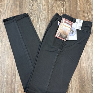 Op de afbeelding: Zwarte denim jeans met een Wrangler Silverlake Original Fit-label eraan bevestigd. Het label toont een panoramisch beeld van een meer en bergen.