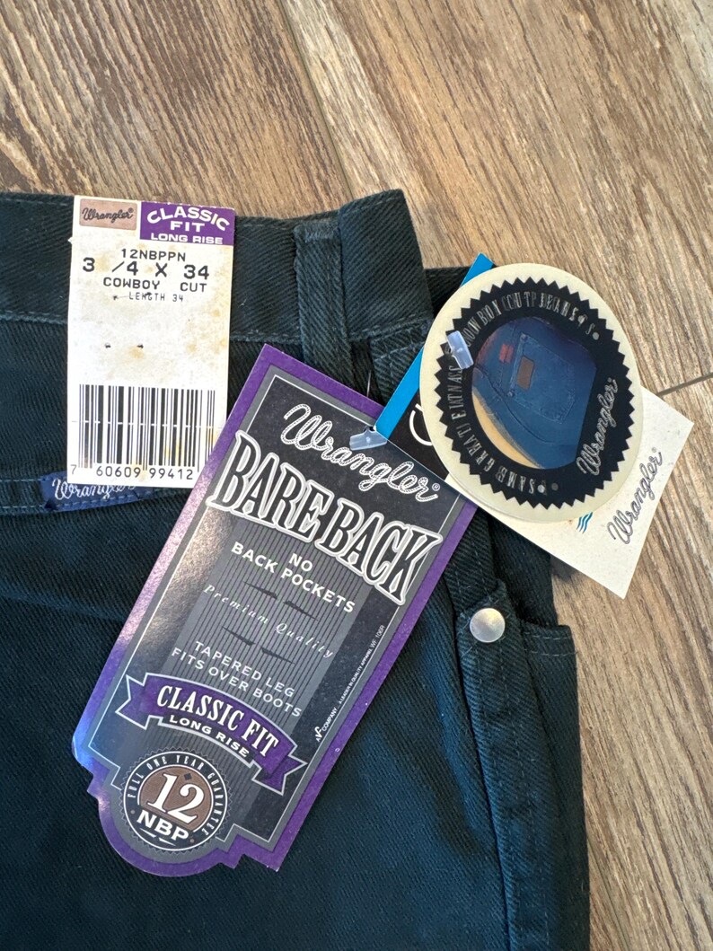 May include: Dark green Wrangler jeans with a purple and white tag that says "Bare Back" and "Classic Fit Long Rise". The tag also says "No Back Pockets" and "Tapered Leg Fits Over Boots".