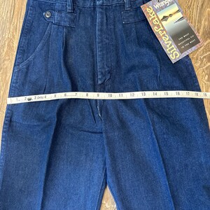 Puede incluir: Pantalones vaqueros azul oscuro con cintura alta y pliegues. Los pantalones tienen cierre de bot&oacute;n y un peque&ntilde;o bolsillo. Una etiqueta dice "Silverlake" y "Wrangler". Los pantalones miden aproximadamente 48 cm en la cintura.